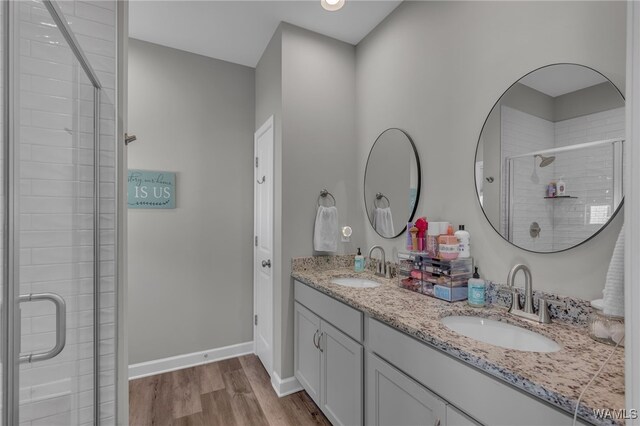 13930 Sullivan Blvd, Northport, AL 35475 - full bathroom featuring a sink, a shower stall, double vanity, and wood finished floors