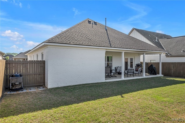 13930 Sullivan Blvd, Northport, AL 35475 - rear view of property with a shingled roof, a fenced backyard, a patio, brick siding, and french doors
