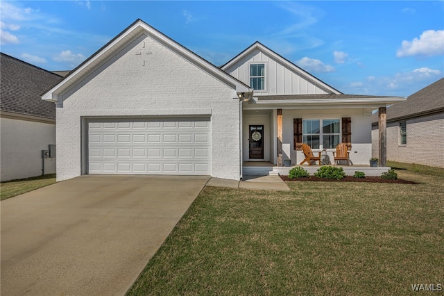 13930 Sullivan Blvd, Northport, AL 35475 - view of front facade featuring concrete driveway, board and batten siding, a front yard, a garage, and covered porch