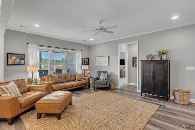 13930 Sullivan Blvd, Northport, AL 35475 - living room featuring light wood-style floors, visible vents, a ceiling fan, and ornamental molding