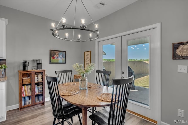 13930 Sullivan Blvd, Northport, AL 35475 - dining area featuring light wood-type flooring, visible vents, a chandelier, french doors, and baseboards