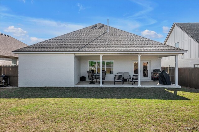 13930 Sullivan Blvd, Northport, AL 35475 - rear view of house featuring roof with shingles, a lawn, fence, and brick siding