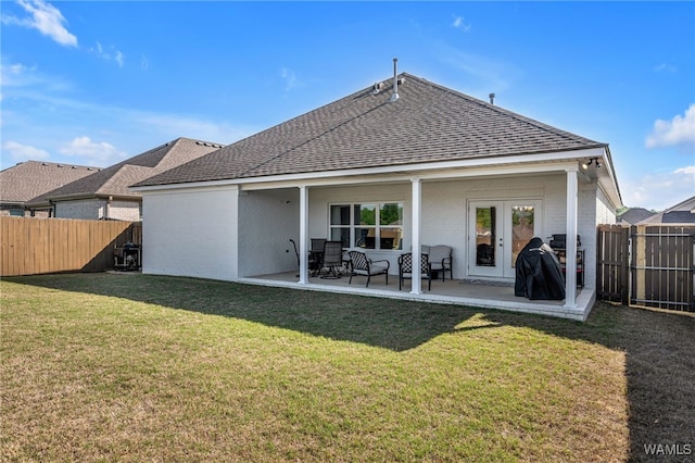 13930 Sullivan Blvd, Northport, AL 35475 - rear view of house featuring a shingled roof, a yard, a fenced backyard, a patio, and brick siding