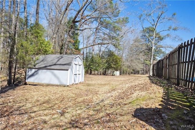 view of yard with a storage unit, an outdoor structure, and fence