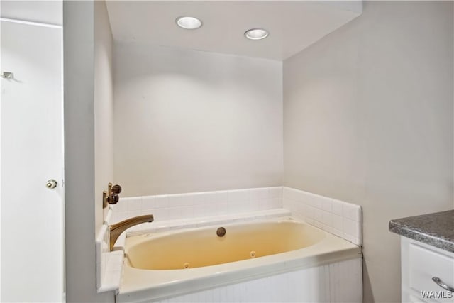 full bathroom with a whirlpool tub and vanity