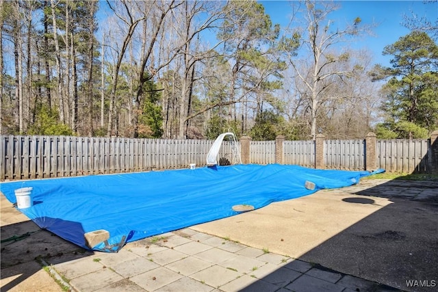 view of swimming pool featuring a fenced backyard and a gate