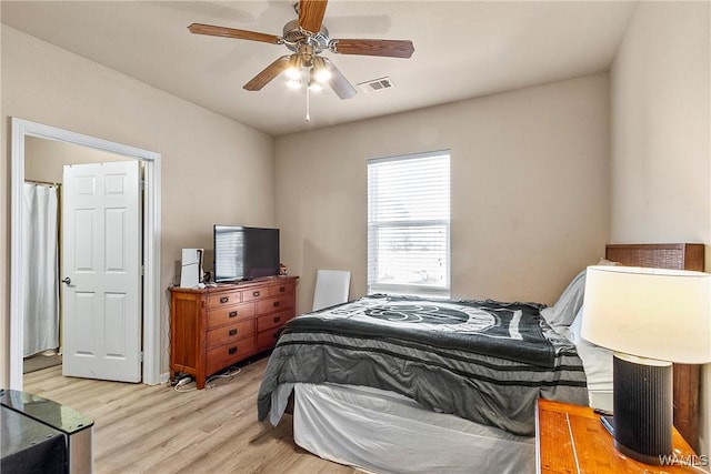 bedroom with ceiling fan, light wood finished floors, and visible vents