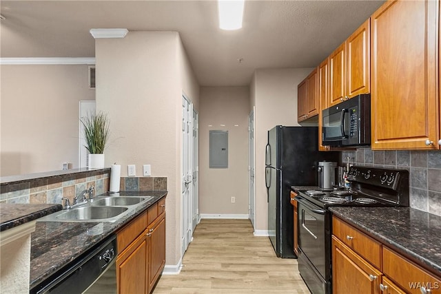 kitchen featuring brown cabinets, a sink, dark stone counters, electric panel, and black appliances