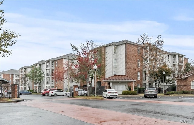 view of property featuring uncovered parking and fence