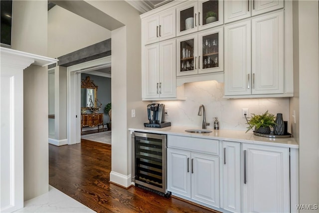 1231 Diamond Point Cir, Tuscaloosa, AL 35406 - bar featuring dark wood-type flooring, a sink, wine cooler, decorative backsplash, and baseboards