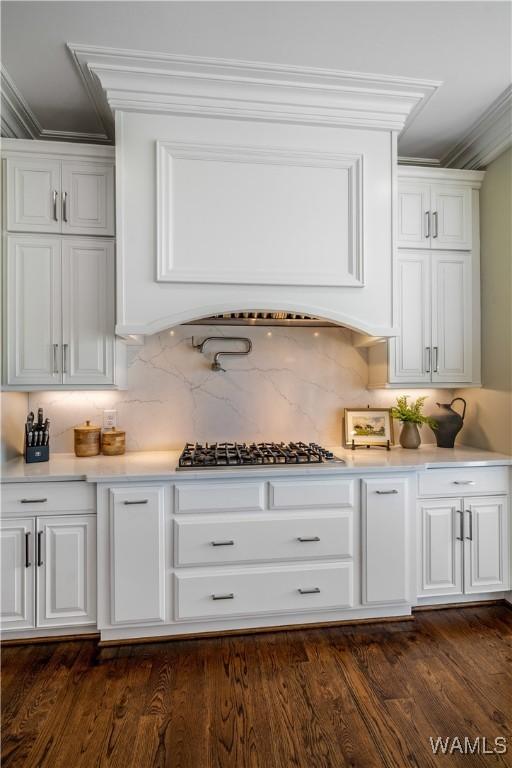 1231 Diamond Point Cir, Tuscaloosa, AL 35406 - kitchen featuring backsplash, dark wood-type flooring, stainless steel gas cooktop, light countertops, and white cabinetry