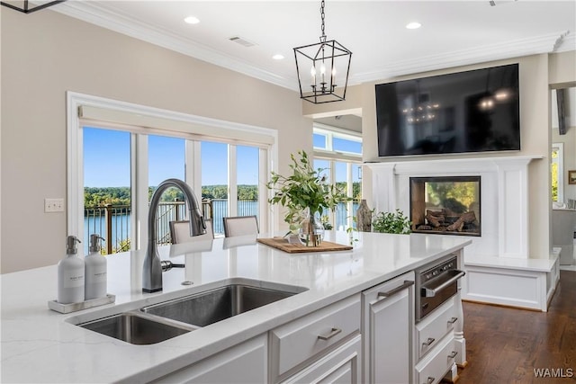 1231 Diamond Point Cir, Tuscaloosa, AL 35406 - kitchen featuring light stone counters, a sink, crown molding, a warming drawer, and a chandelier