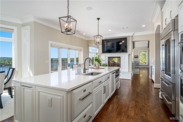 1231 Diamond Point Cir, Tuscaloosa, AL 35406 - kitchen with a sink, open floor plan, white cabinetry, crown molding, and light countertops