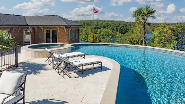 1231 Diamond Point Cir, Tuscaloosa, AL 35406 - view of swimming pool featuring a pool with connected hot tub, a patio, a view of trees, an exterior structure, and french doors