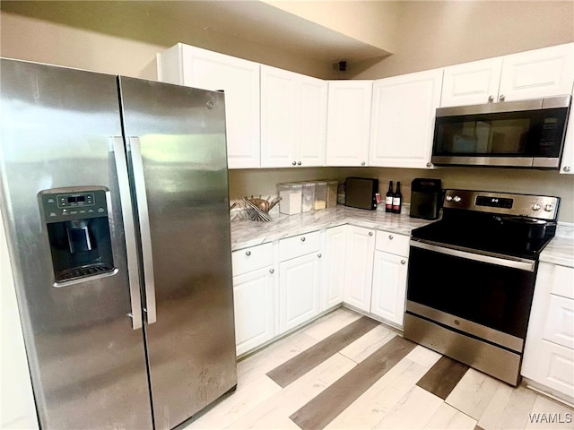 5211 Briarcliff Dr, Northport, AL 35473 - kitchen with appliances with stainless steel finishes, light countertops, and white cabinetry