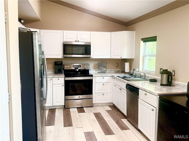5211 Briarcliff Dr, Northport, AL 35473 - kitchen featuring stainless steel appliances, white cabinets, crown molding, light wood-style floors, and vaulted ceiling