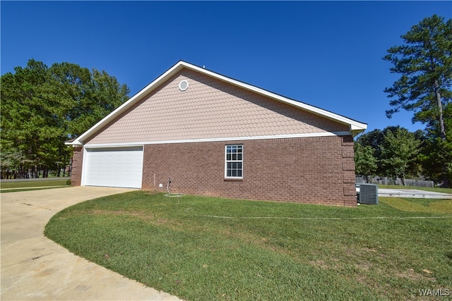 view of side of property featuring a yard, central AC, and a garage