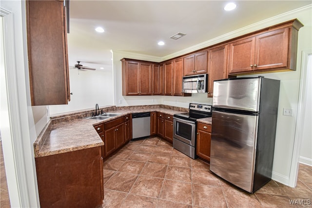 kitchen featuring dark tile patterned flooring, sink, crown molding, ceiling fan, and stainless steel appliances