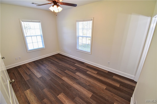 spare room with a wealth of natural light, ceiling fan, and dark hardwood / wood-style floors