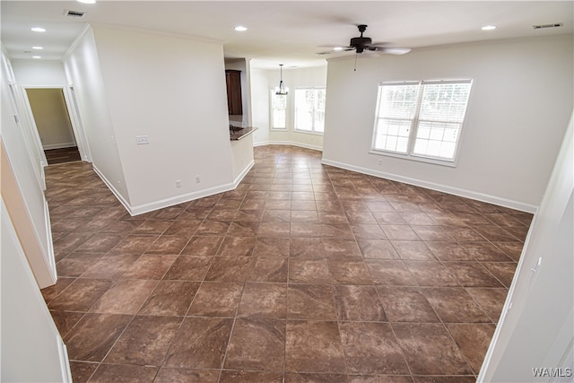 spare room with ceiling fan with notable chandelier