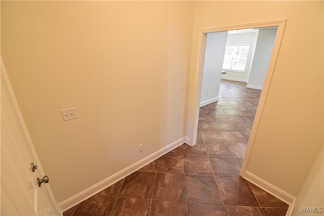 hallway with dark tile patterned flooring