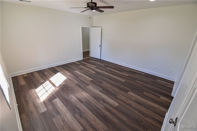 empty room with ceiling fan and dark wood-type flooring