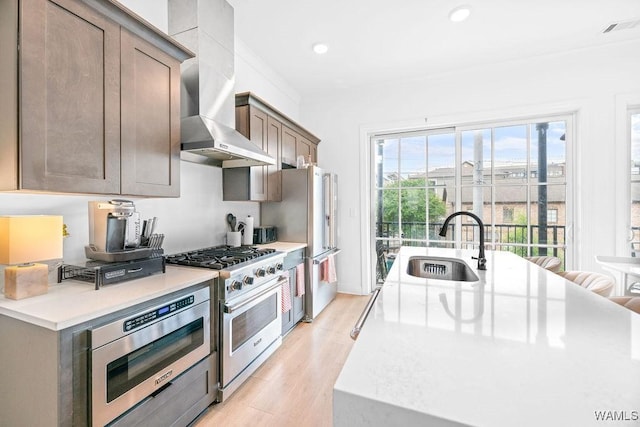 800 Red Drew Ave, Tuscaloosa, AL 35401 - kitchen with stainless steel appliances, wall chimney range hood, light wood-style flooring, light countertops, and recessed lighting