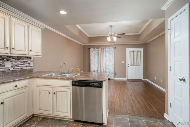 kitchen featuring a tray ceiling, dishwasher, sink, kitchen peninsula, and cream cabinetry