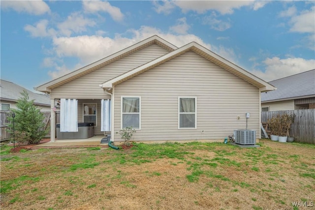 rear view of property featuring a yard, a patio area, and central air condition unit