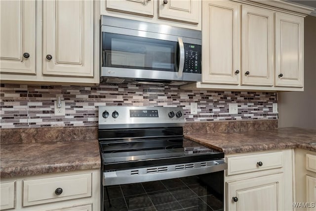 kitchen with backsplash, stainless steel appliances, and cream cabinetry