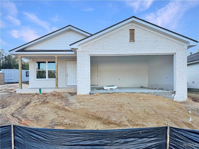 view of front of house with an attached garage, fence, and brick siding