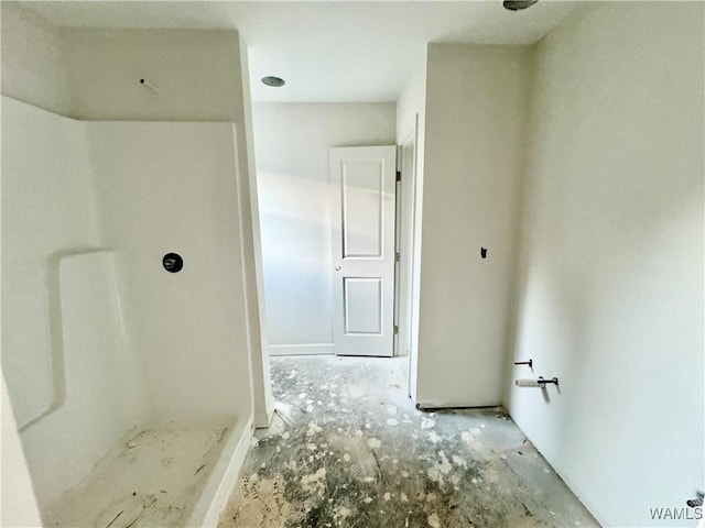 bathroom featuring a shower and concrete floors