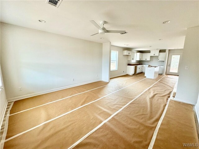 unfurnished living room with ceiling fan, sink, and dark hardwood / wood-style floors