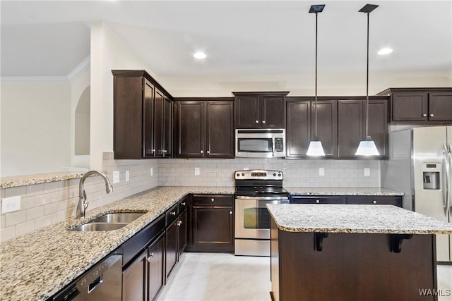 9437 Crete Cir, Tuscaloosa, AL 35406 - kitchen with appliances with stainless steel finishes, crown molding, a center island, dark brown cabinetry, and light stone countertops