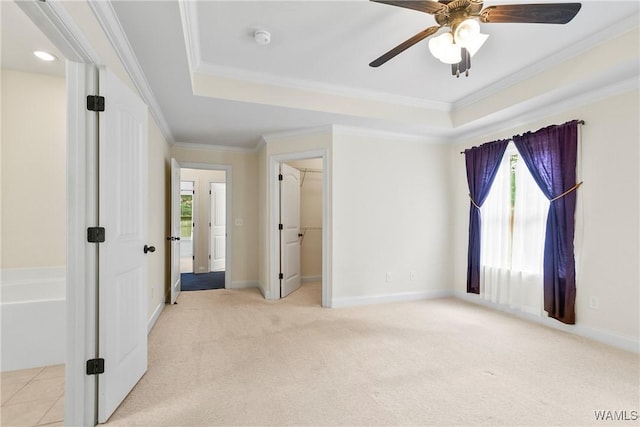 9437 Crete Cir, Tuscaloosa, AL 35406 - unfurnished bedroom featuring a tray ceiling, light colored carpet, ornamental molding, a walk in closet, and ceiling fan
