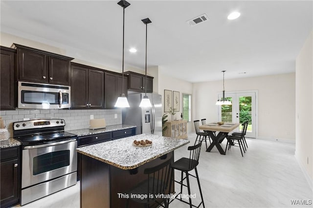 9437 Crete Cir, Tuscaloosa, AL 35406 - kitchen with stainless steel appliances, dark brown cabinetry, light stone countertops, decorative backsplash, and recessed lighting