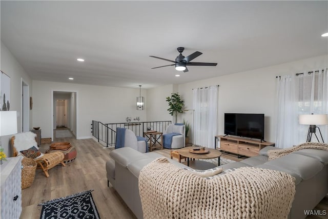 living room featuring ceiling fan and light hardwood / wood-style flooring