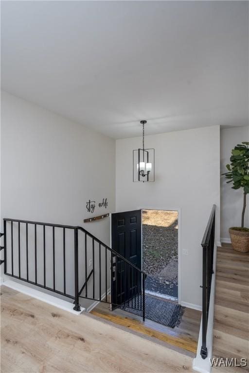 entryway with light hardwood / wood-style floors and a notable chandelier