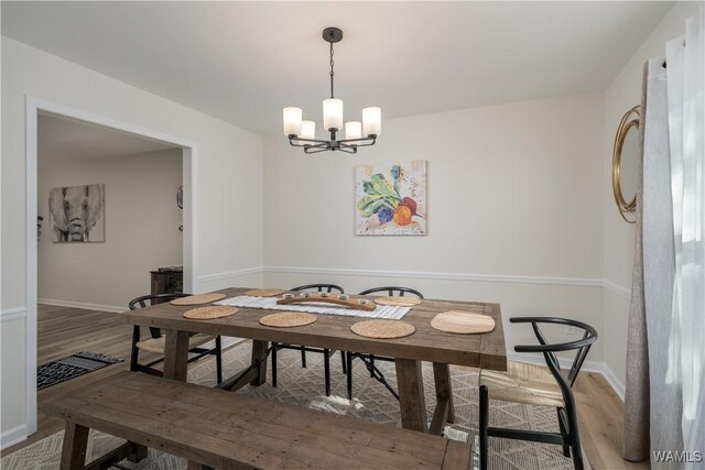 dining area with hardwood / wood-style flooring and a chandelier