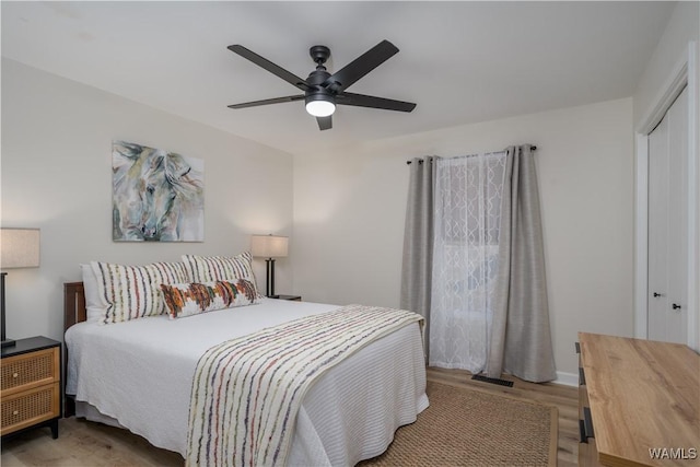 bedroom with ceiling fan, a closet, and light hardwood / wood-style floors