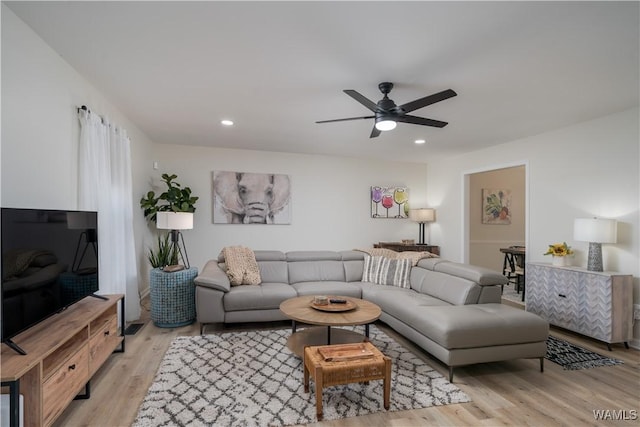 living room with light hardwood / wood-style flooring and ceiling fan