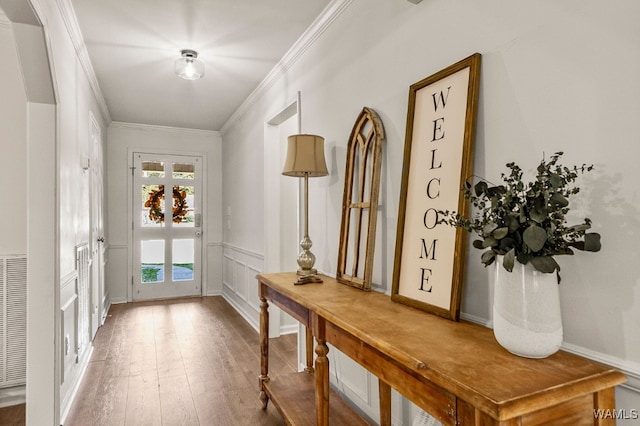 doorway to outside featuring hardwood / wood-style flooring and ornamental molding