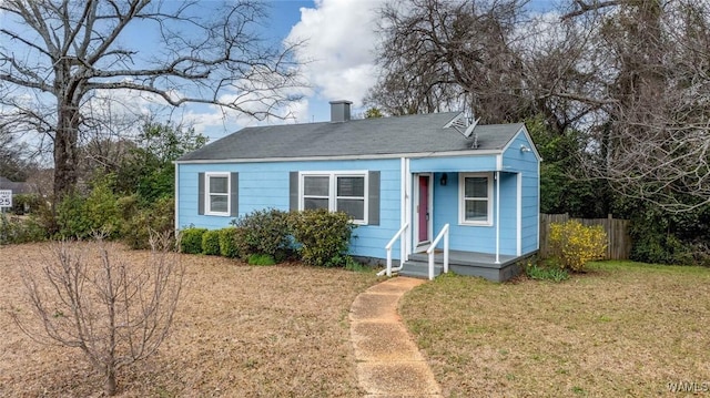 bungalow-style home featuring fence and a front lawn