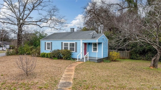 bungalow-style house with fence and a front lawn