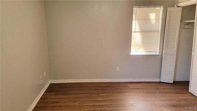 unfurnished bedroom with a closet and dark hardwood / wood-style flooring