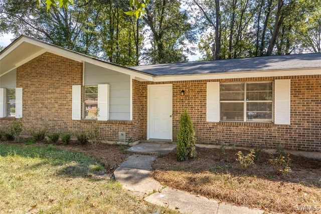 property entrance featuring a lawn