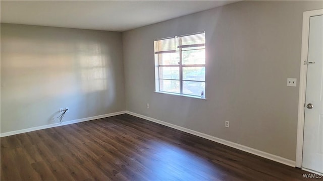 unfurnished room with dark hardwood / wood-style flooring