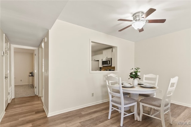 dining space with ceiling fan and light hardwood / wood-style floors