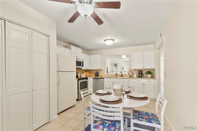 kitchen with tasteful backsplash, white cabinetry, sink, and appliances with stainless steel finishes