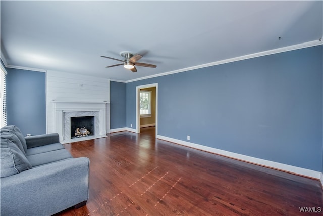 living room with ceiling fan, dark hardwood / wood-style flooring, crown molding, and a high end fireplace